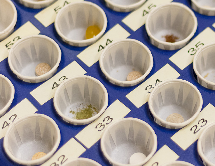 Various pills and minerals in testing cups